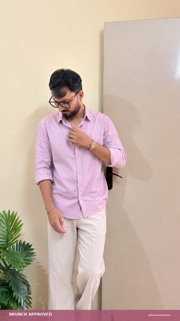 Man wearing a pastel pink shirt with cream trousers for brunch style