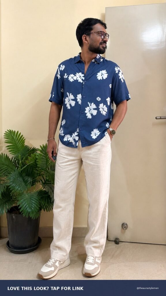 Pinterest style Pin featuring a man wearing a blue floral printed oversized shirt with short sleeves and a spread collar. The layout highlights the relaxed fit, floral pattern, and casual summer styling in a clean editorial design.