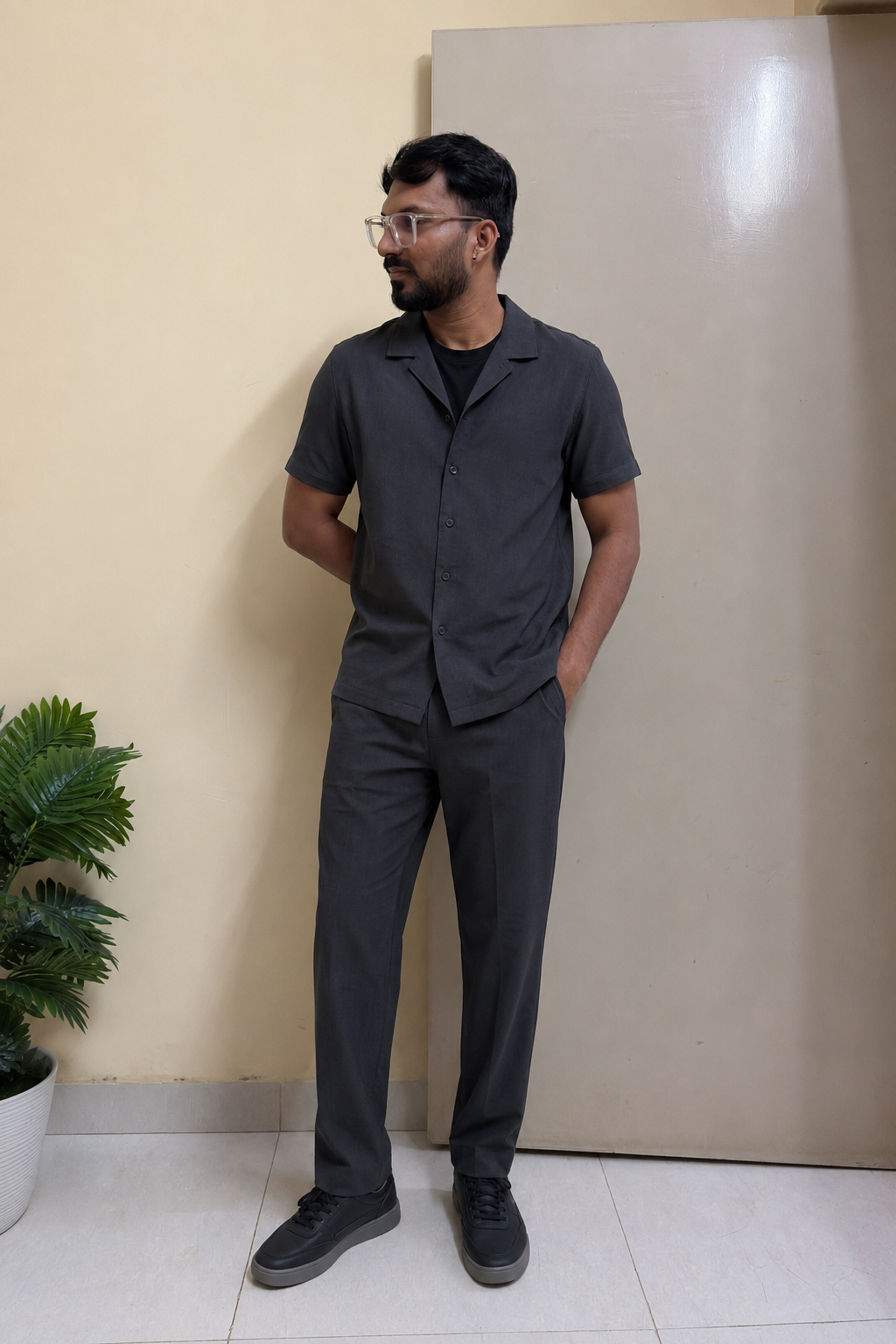 Indian man wearing a charcoal short-sleeve co-ord set with tonal sneakers for monsoon style