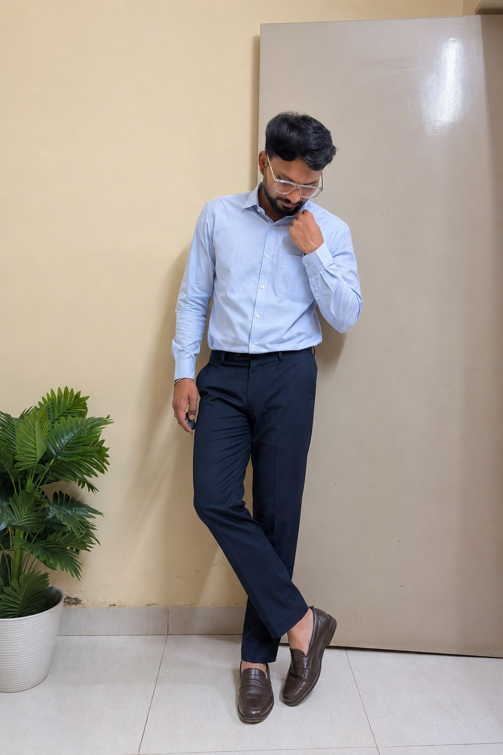 Indian man wearing a light-blue shirt, navy trousers and dark-brown loafers as a monsoon office outfit